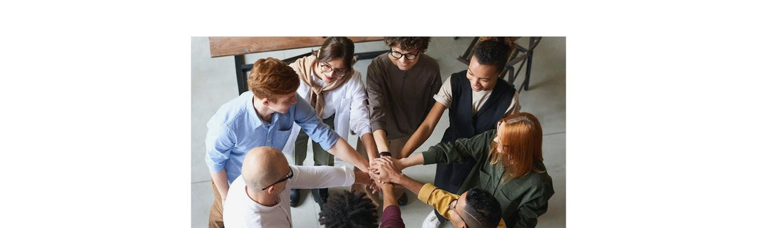 A diverse group of coworkers placing their hands in a circle.